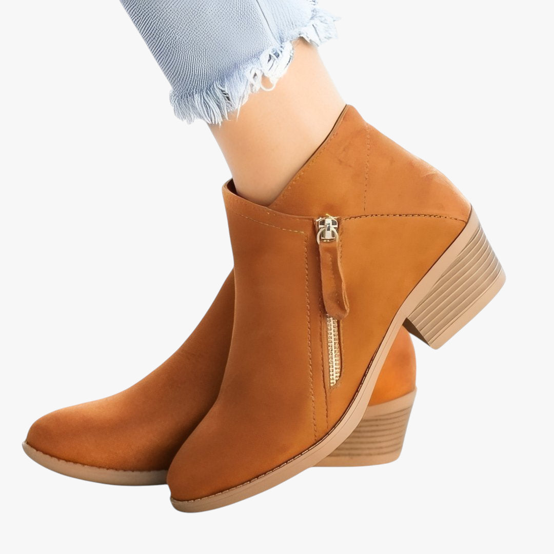 Brown ankle boots with a gold zipper on a white background